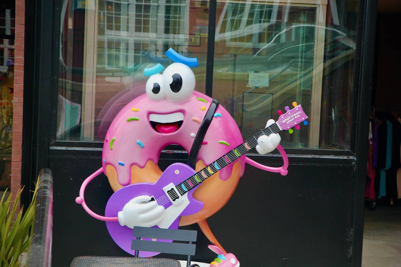 Statue of a donut playing an electric guitar for Rock 'n Roll Donut Bar, Monterey, California